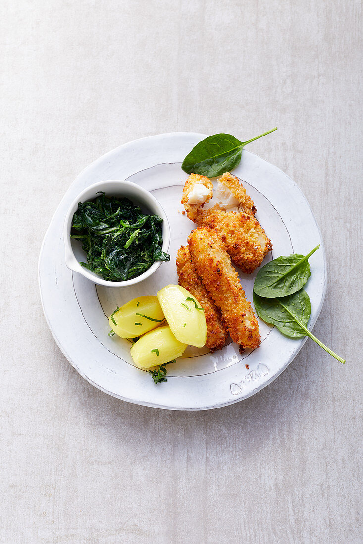 Homemade fish fingers with spinach and boiled potatoes