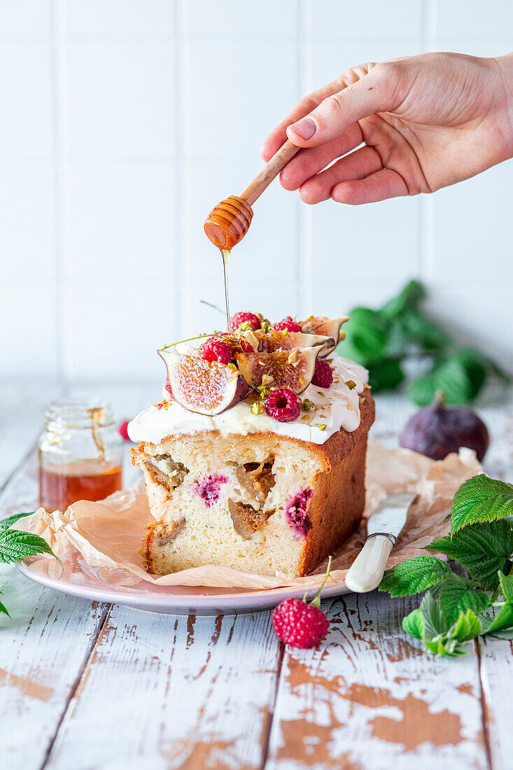 Feigen-Himbeer-Kuchen wird mit Honig beträufelt