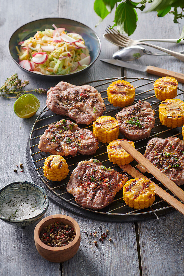 Gegrillte Schweinekoteletts mit Mais und Gemüsesalat