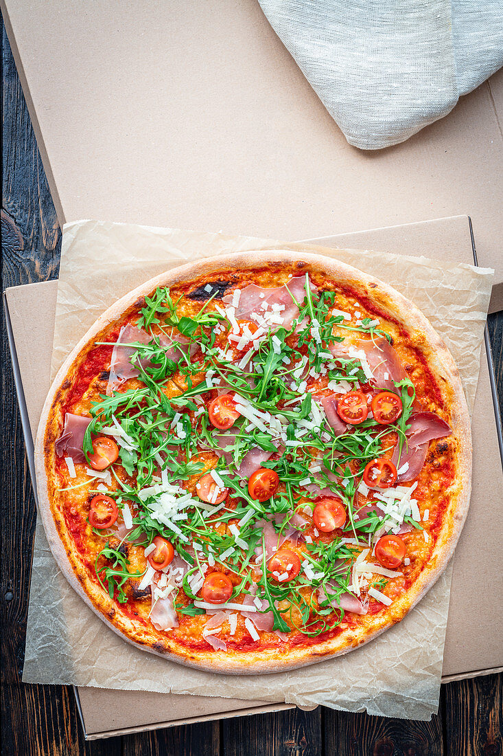 Pizza with prosciutto and cherry tomatoes