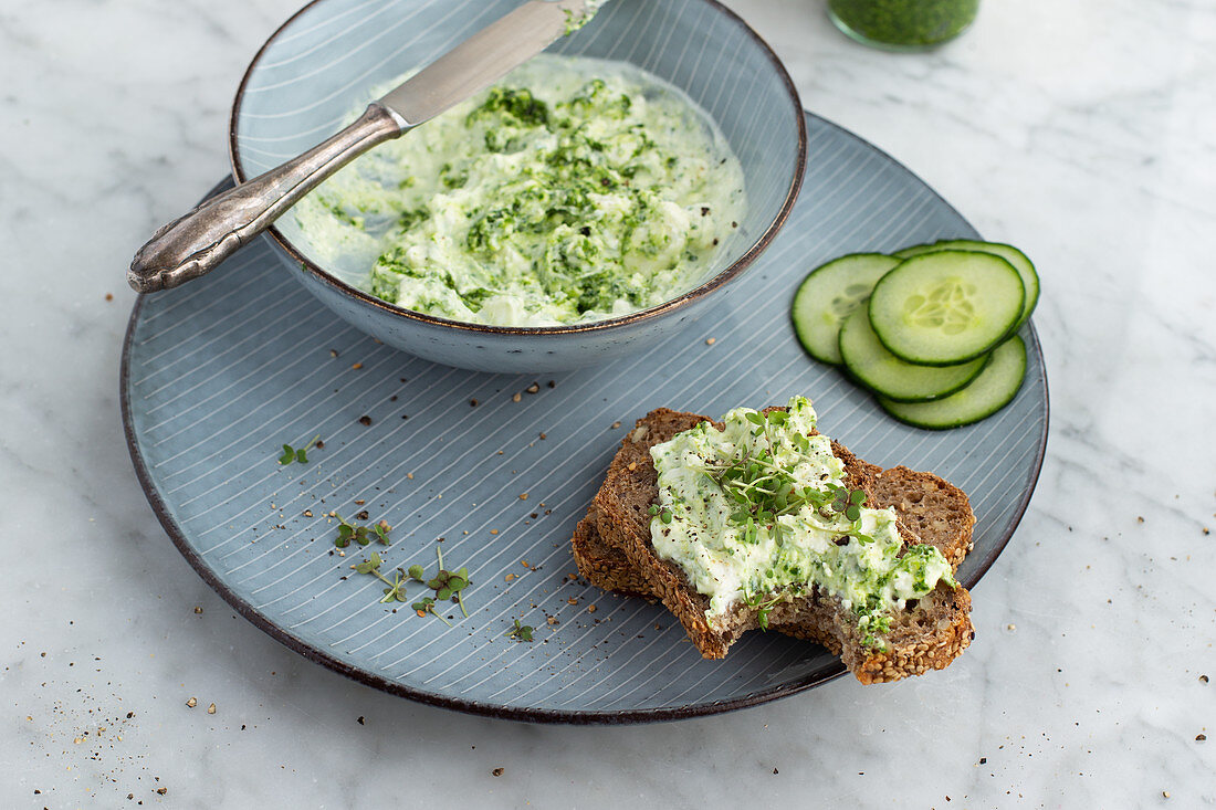 Wild garlic sheep's cheese cream on wholemeal bread with cucumber slices