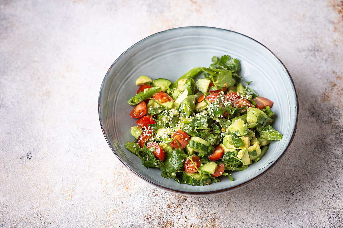 Gemüsesalat mit Zuckerschoten, Avocado, Tomaten, Gurken und Koriander