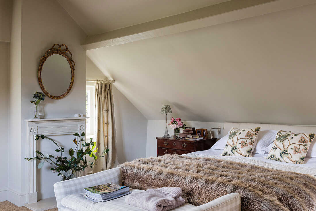 Leaf arrangement in attic room with double bed and fur throw