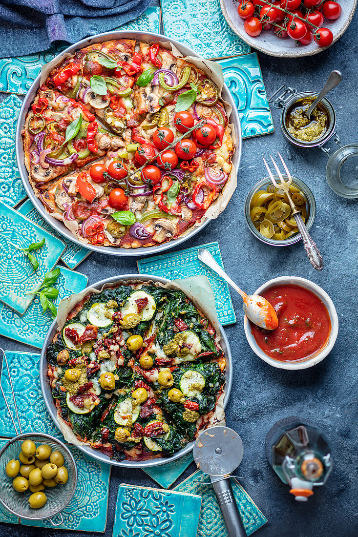 Two vegetarian pizzas with mushrooms, pepper, jalapeno, tomatoes, spinach, courgette, dried tomatoes
