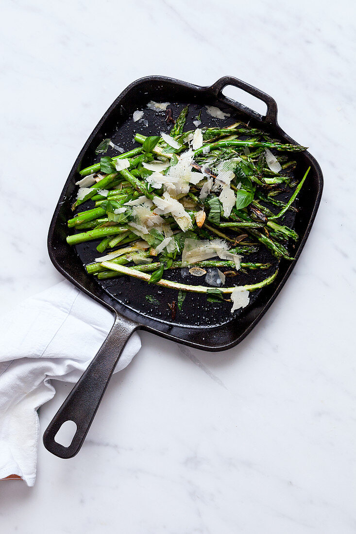Green asparagus with parmesan in a pan