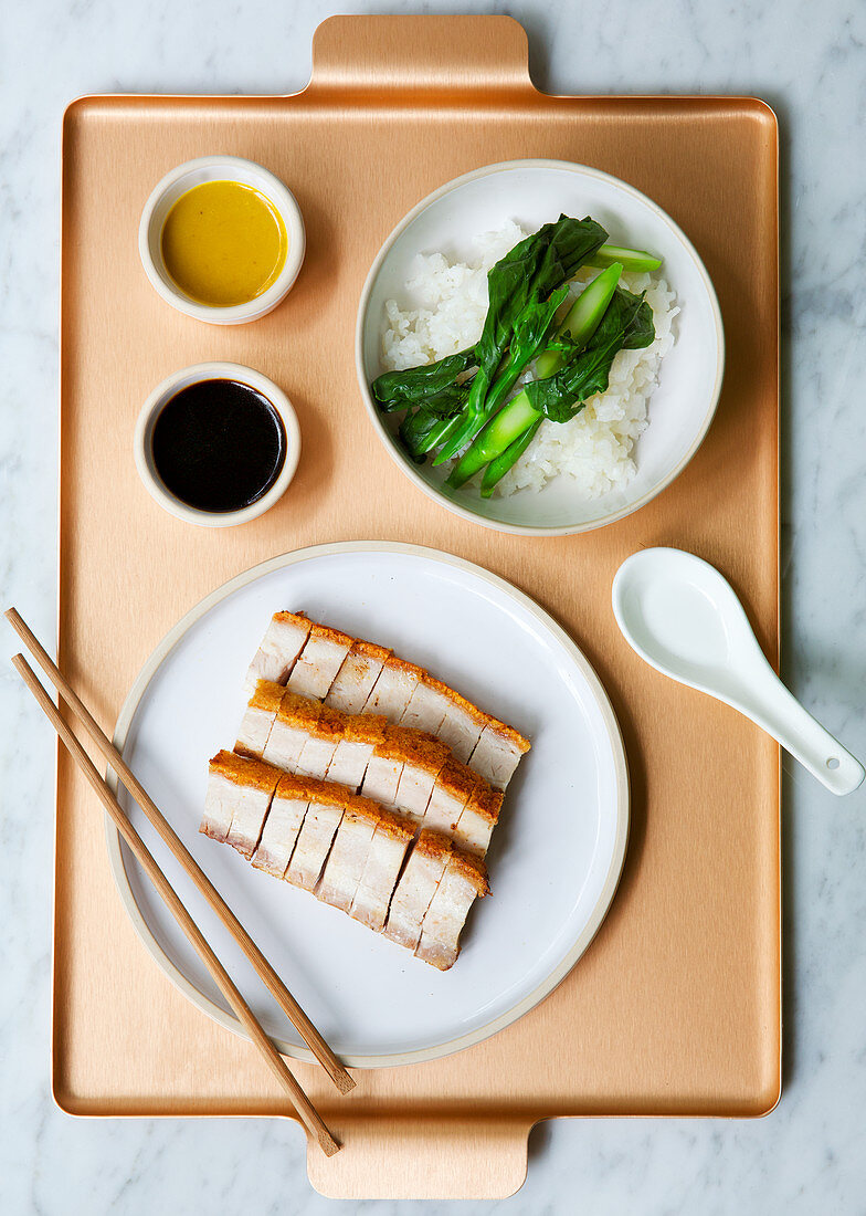 Chinesischer Schweinebauch mit Reis und Gemüse auf Tablett