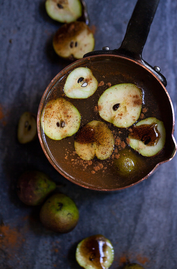 Copper pot with apple cider with small seckel pears, cinnamon and vanilla bean syrup