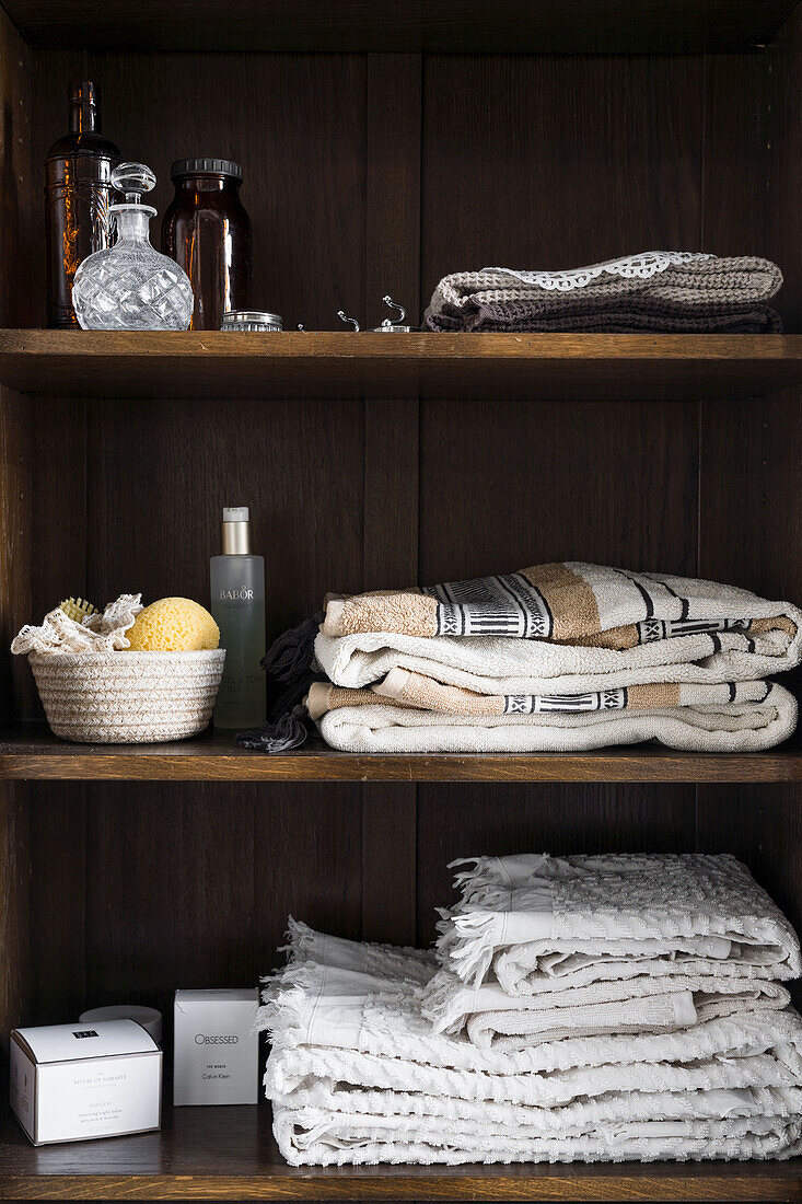 Badeutensilien im Schrank aus dunklem Holz