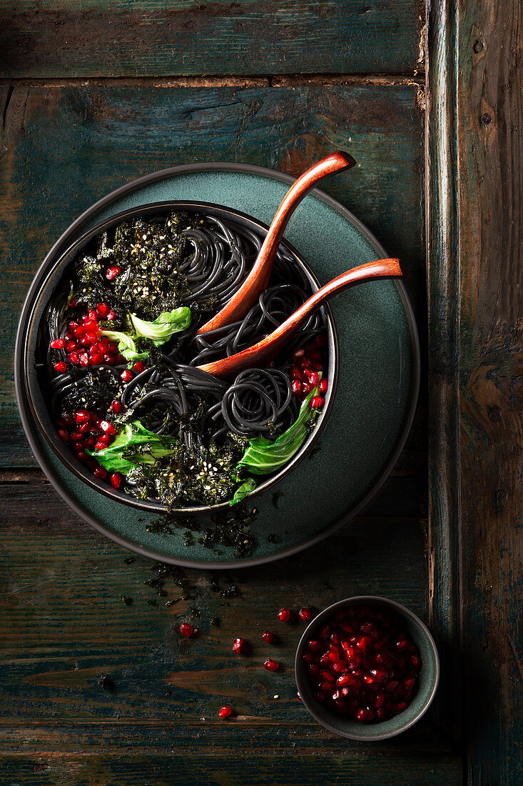 Black spaghetti with pak choy, pomegranate seeds and seaweed