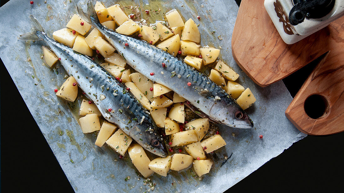Raw mackerel on a potato bed in parchment paper