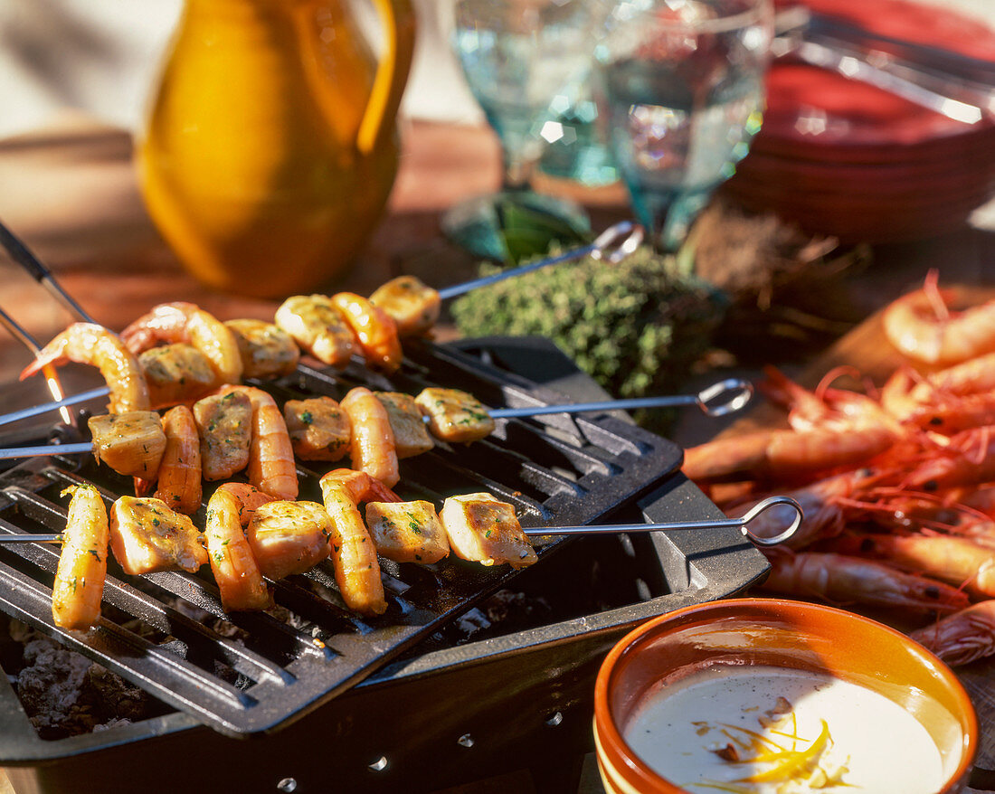 Chicken and prawn kebabs on a grill