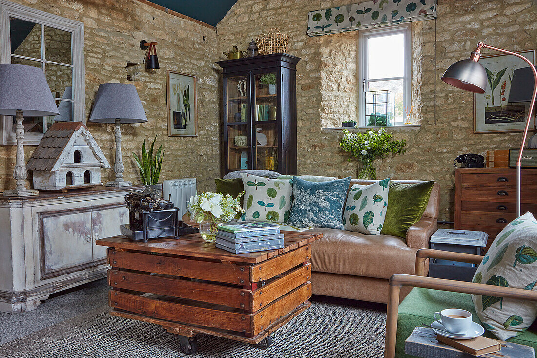 DIY coffee table made from reclaimed wood on castors in living room with stone walls