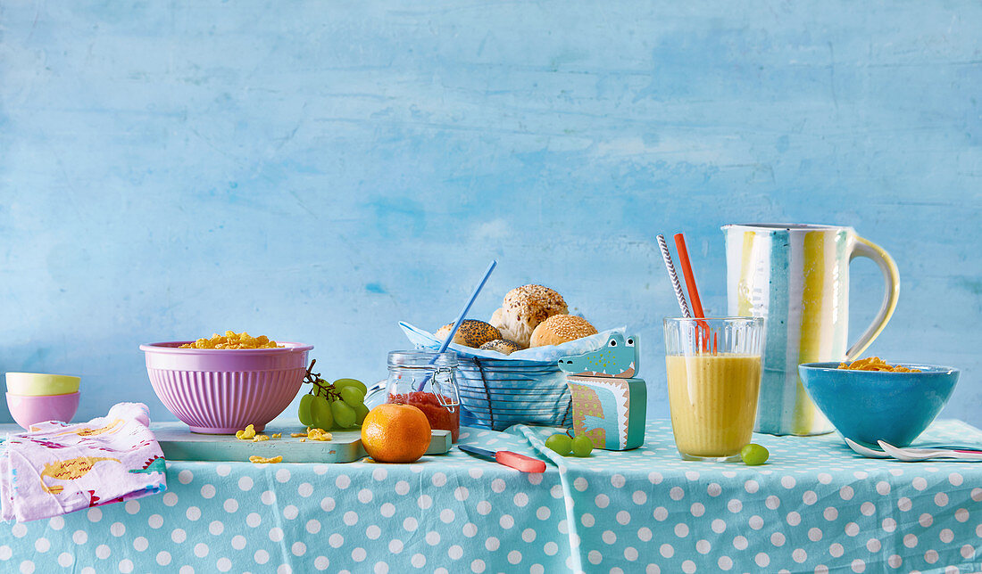 Breakfast table with rolls, juice, muesli and fruit for children