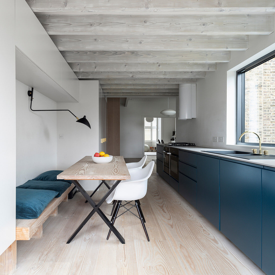 Moderne offene Küche mit blauen Fronten, Esstisch und Balkendecke