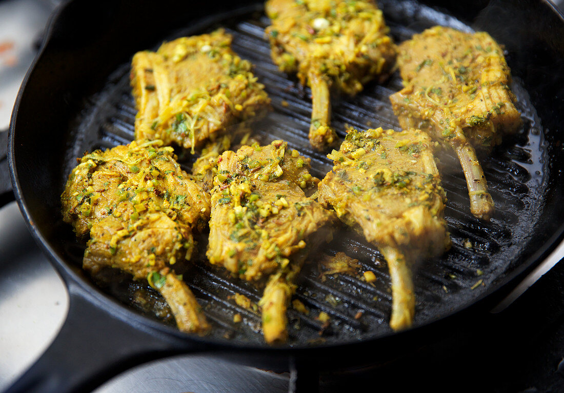 Lamb chops marinated with herbs and spices on a grill (India)
