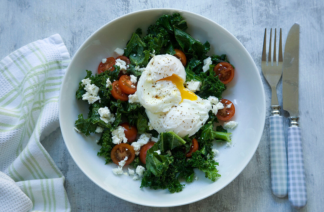 Kale salad with tomato, feta and poached eggs