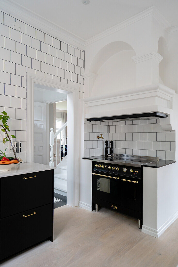 Nostalgic kitchen stove under an extractor hood with a stucco finish