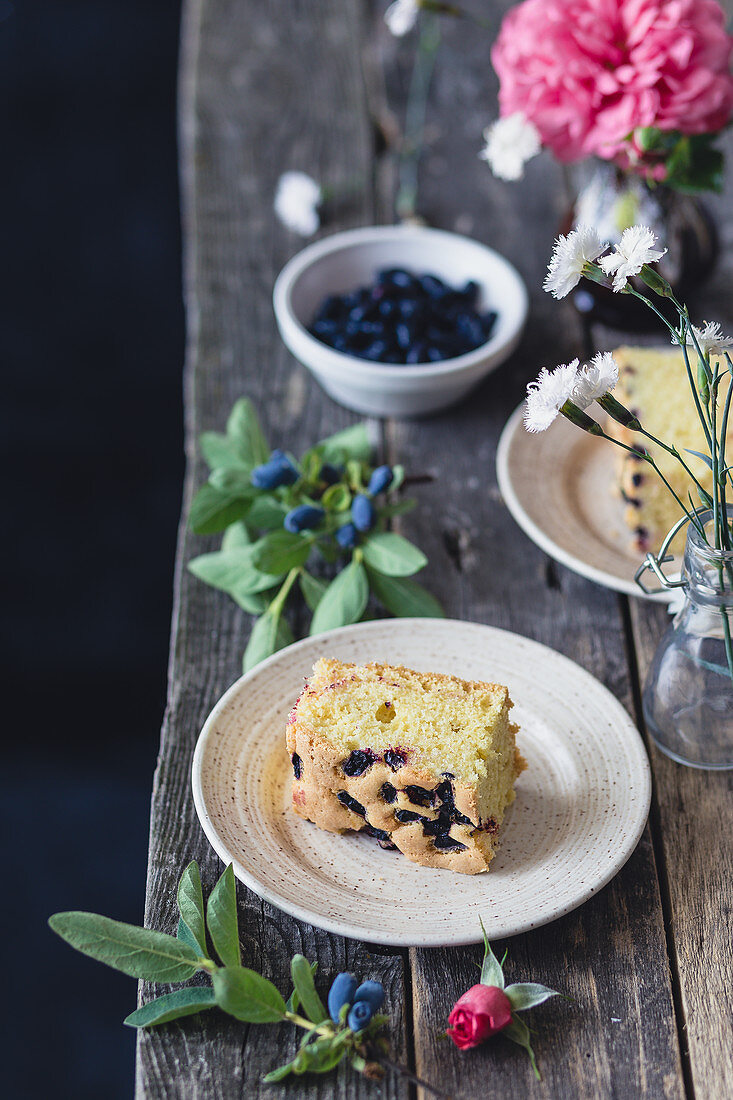 Ein Stück Heidelbeer-Vanille-Kuchen auf Holztisch