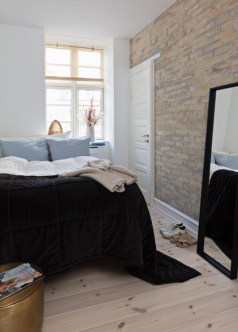 Bedroom with an exposed brick wall and wooden floor