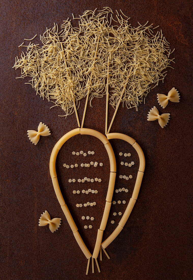 A carrot made from raw pasta shapes