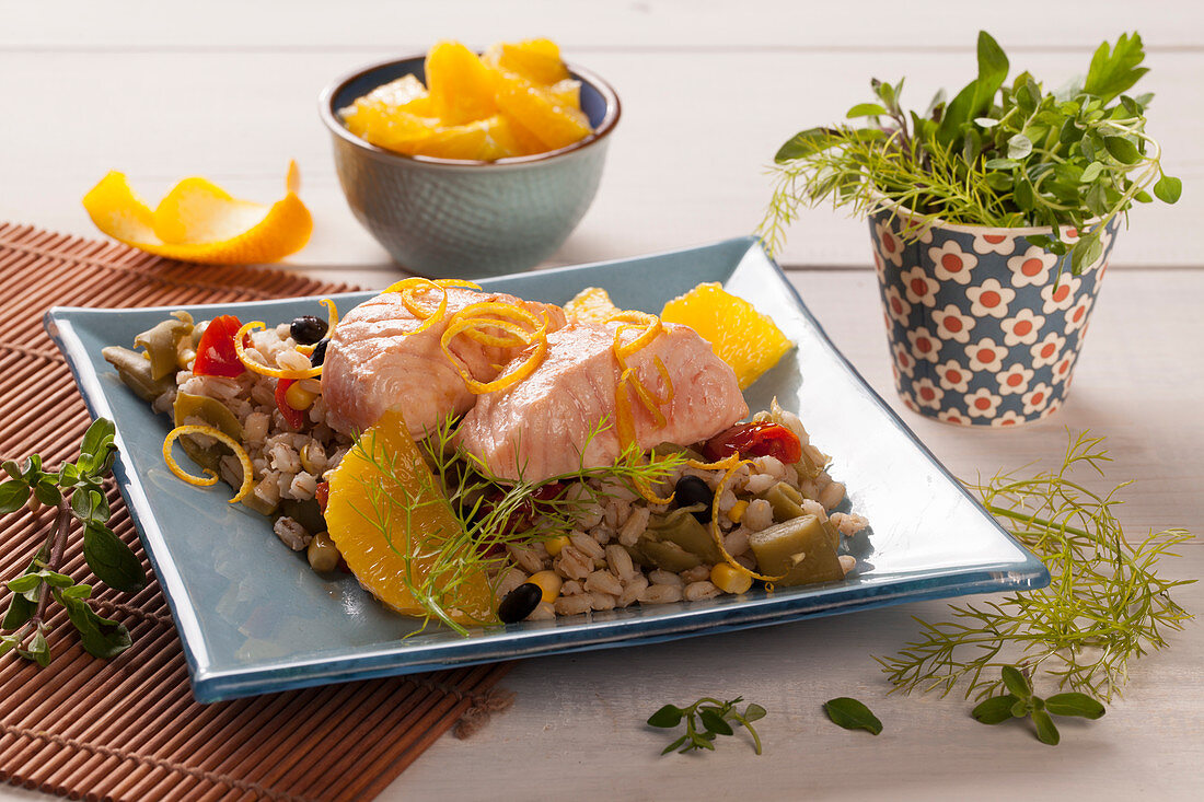 Poached salmon filet on a barley salad with oranges