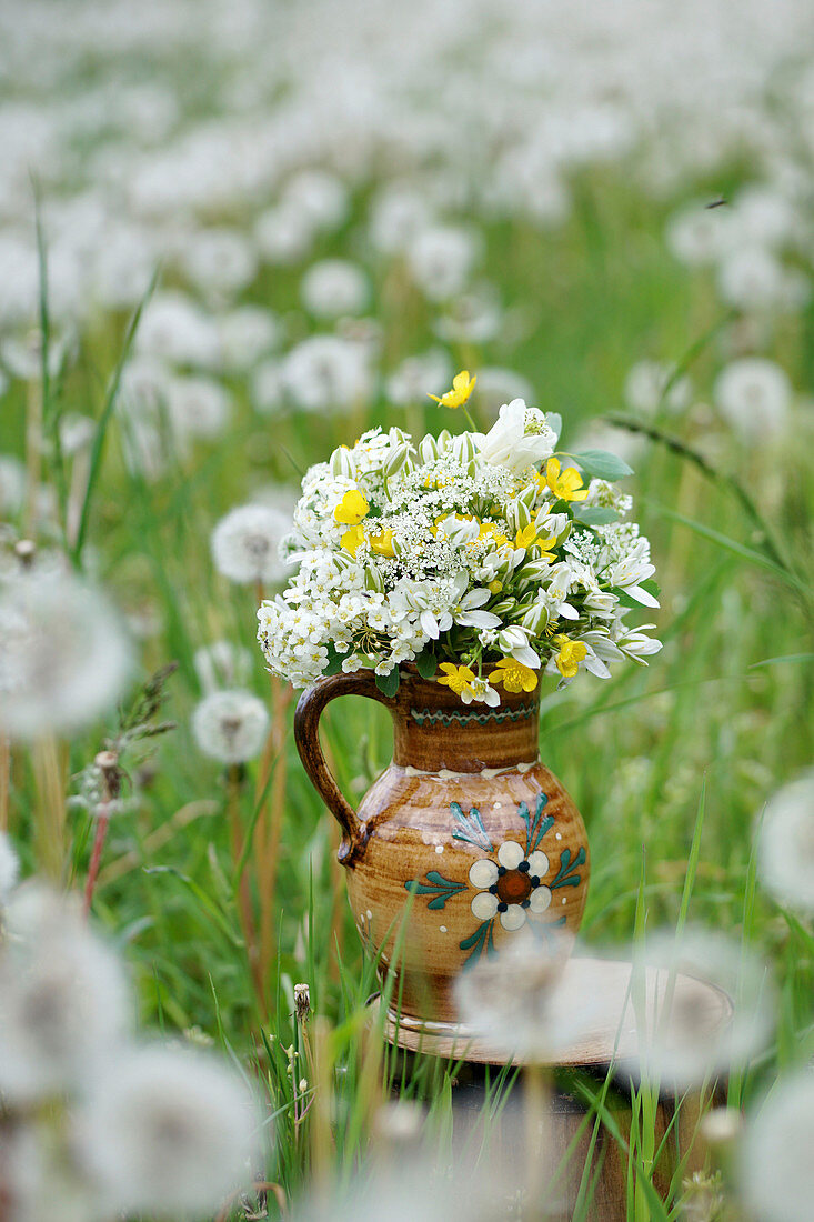 Strauß aus Milchstern, Butterblumen und Spierstrauch in bäuerlichem Keramikkrug