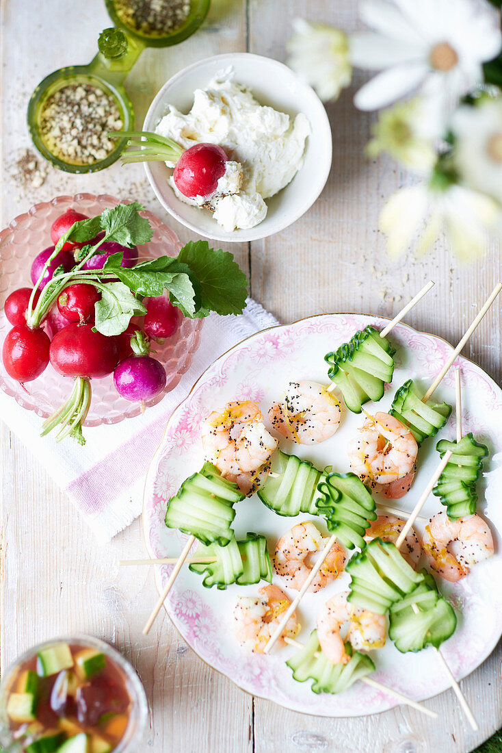 Cold cucumber-shrimp skewers, served with radishes and a dip