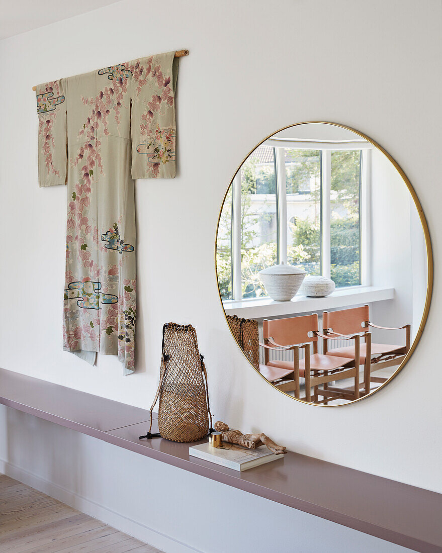 Shelf, above antique kimono and round mirror on white wall