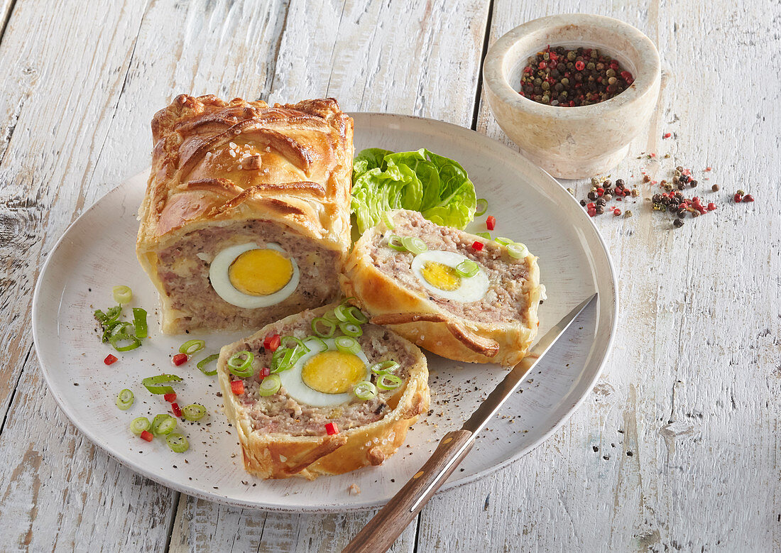Minced meat loag with boiled eggs in puff pastry