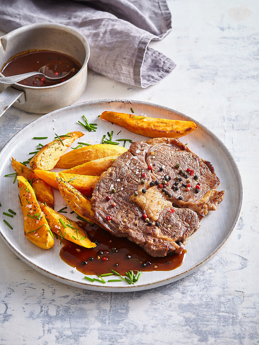 Rib-Eye-Steak mit gebackenen Süßkartoffeln und Pfeffersauce