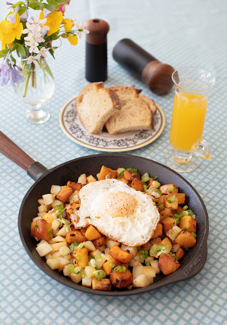 Bratkartoffeln und Süßkartoffeln aus der Pfanne mit Spiegelei