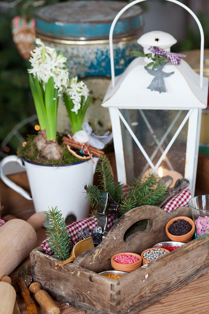 Wooden box with scattered decoration, behind it a lantern and hyacinths