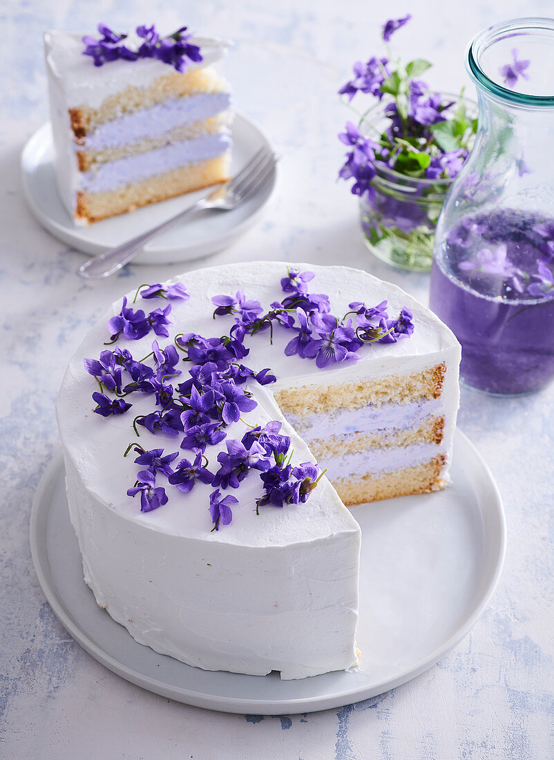 Weiße Sahnecremetorte mit Veilchen, angeschnitten