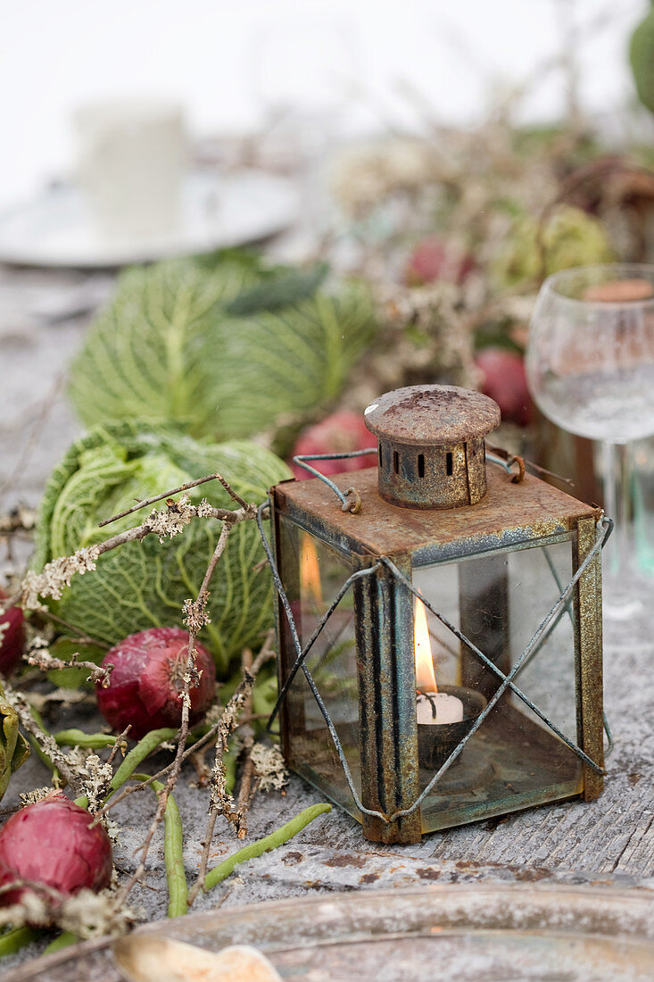 Vintage lantern, red onions, and cabbage heads as table decorations