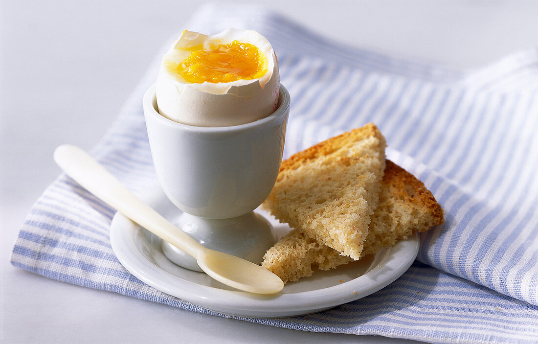 Breakfast egg in a cup and toast slices