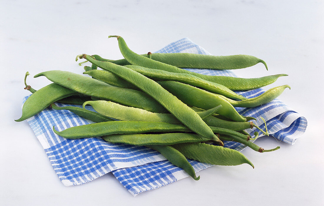 Runner beans on a blue and white cloth