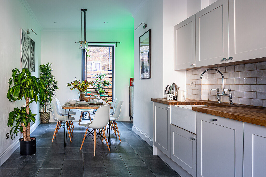 Dining table in an eat-in kitchen with grey kitchen counter and house plants