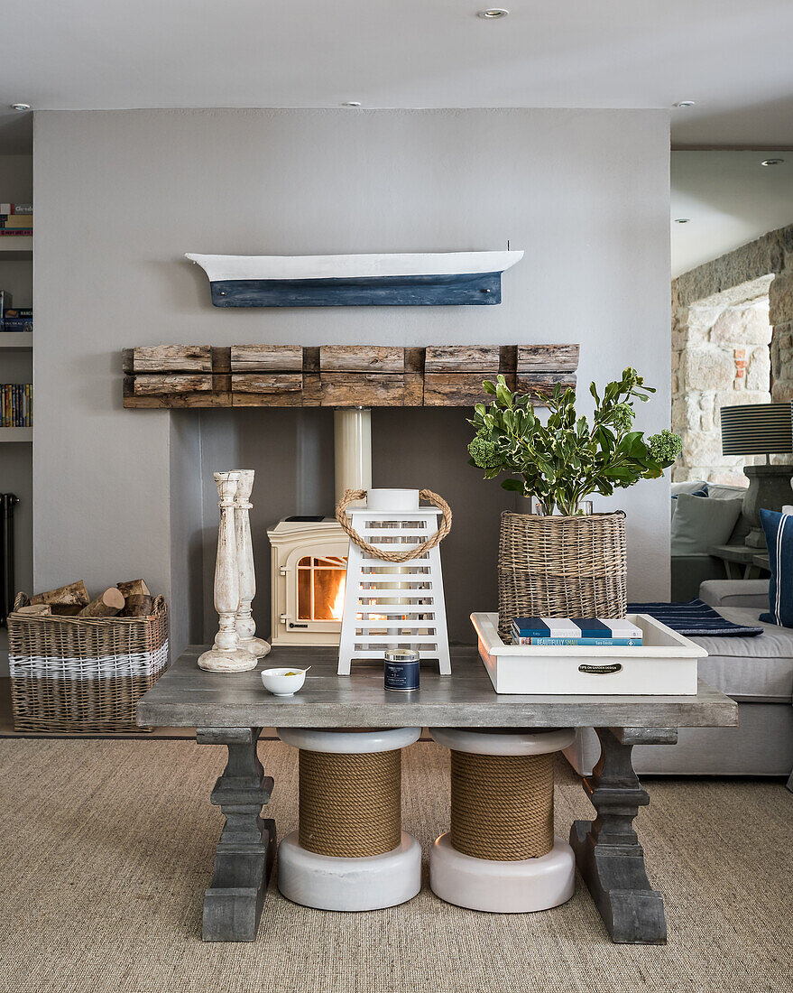 A pair stools under thick-set wooden coffee table in sitting room with wood stove