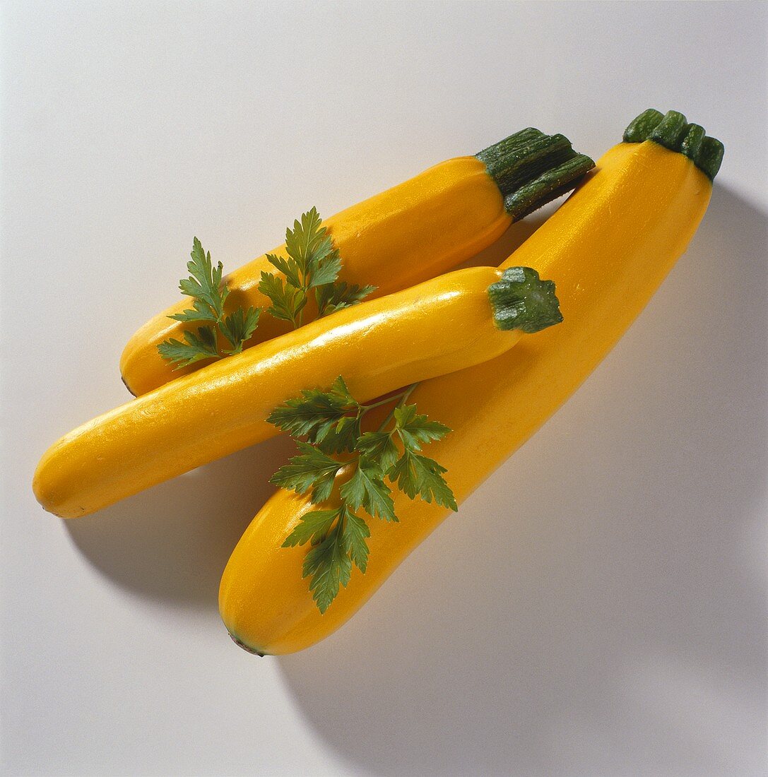 Drei gelbe Zucchini & Petersilienblätter