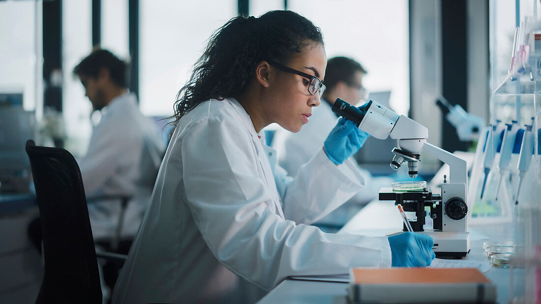 Scientist using microscope in laboratory