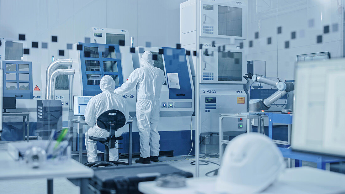 Workers in masks working on a CNC machine