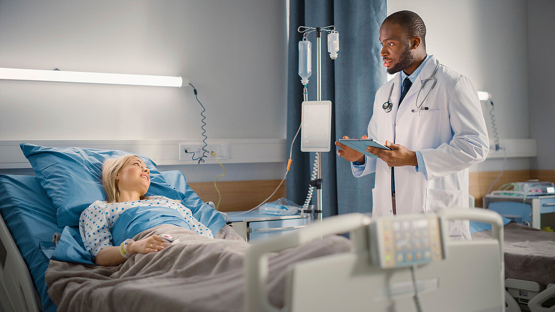 Doctor talking to patient on hospital ward