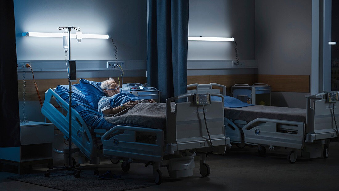 Man wearing oxygen mask in hospital bed