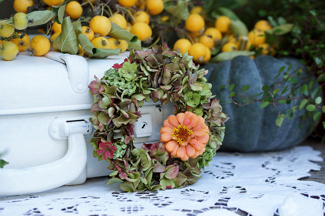 Wreath of hydrangeas with one zinnia flower, branch of crabapples and pumpkin