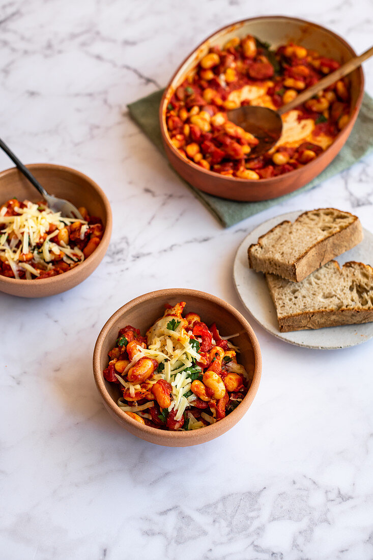 Oven baked beans with baked eggs, grated cheese and sourdough bread