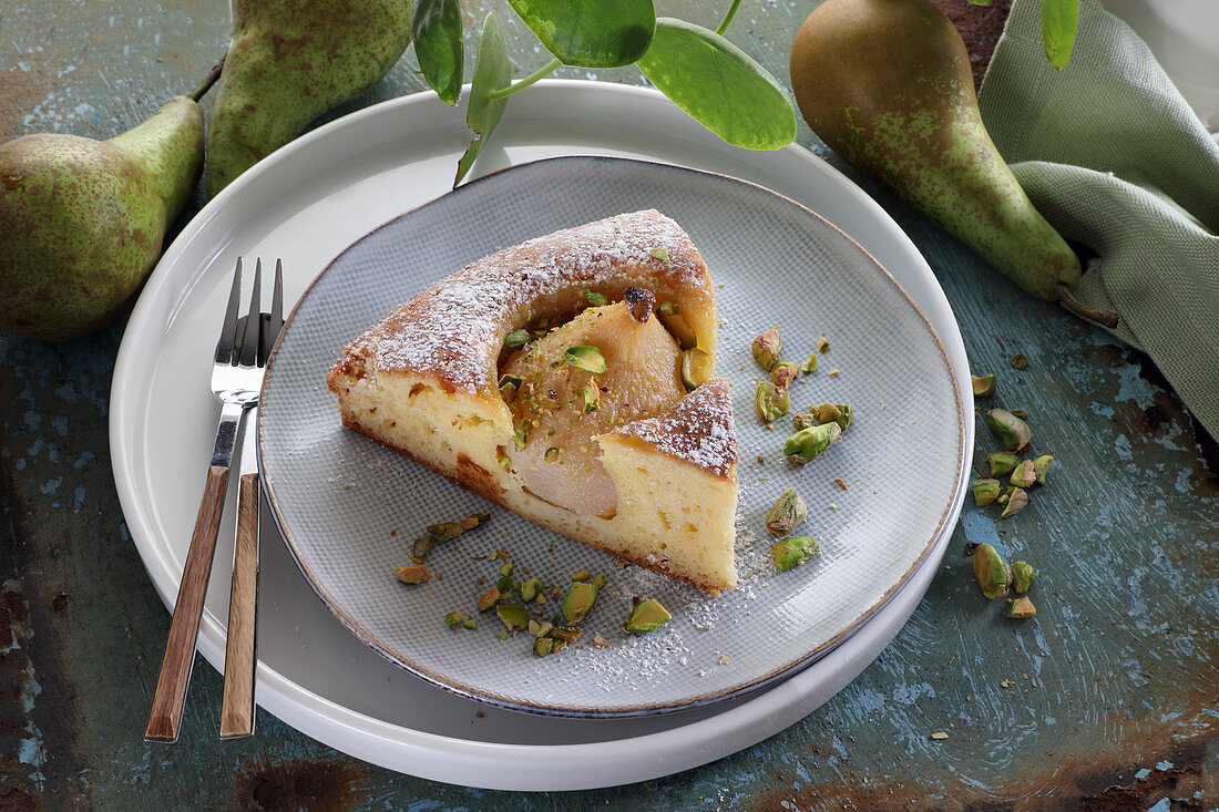 Ein Stück Joghurtkuchen mit Birnen und Pistazien