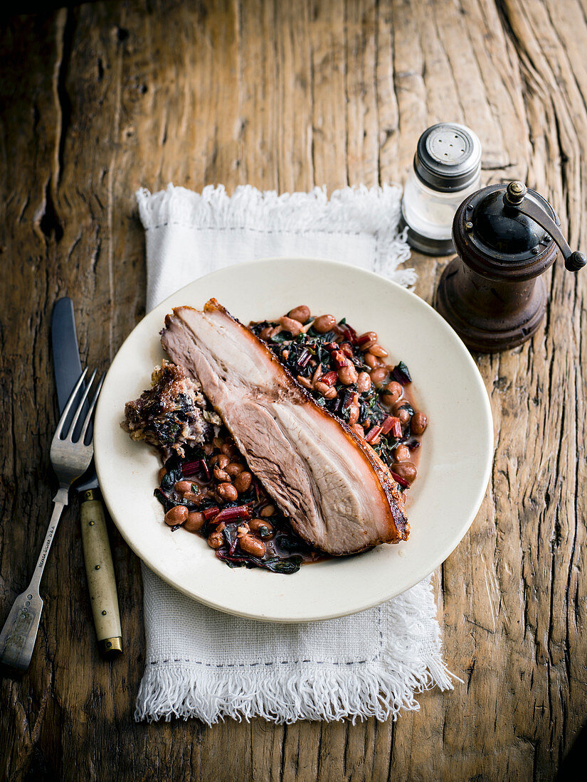 Pork belly with quince sage and black pudding stuffing and borlotti bean ragout