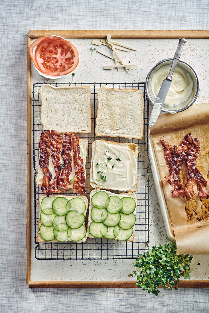 Preparation of club sandwiches with bacon, cucumber and tomatoes