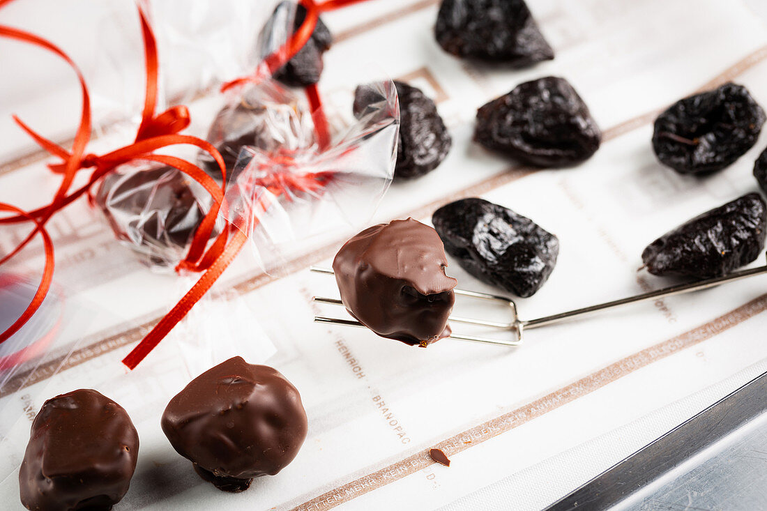 Dried plums with chocolate icing as an edible Christmas decoration