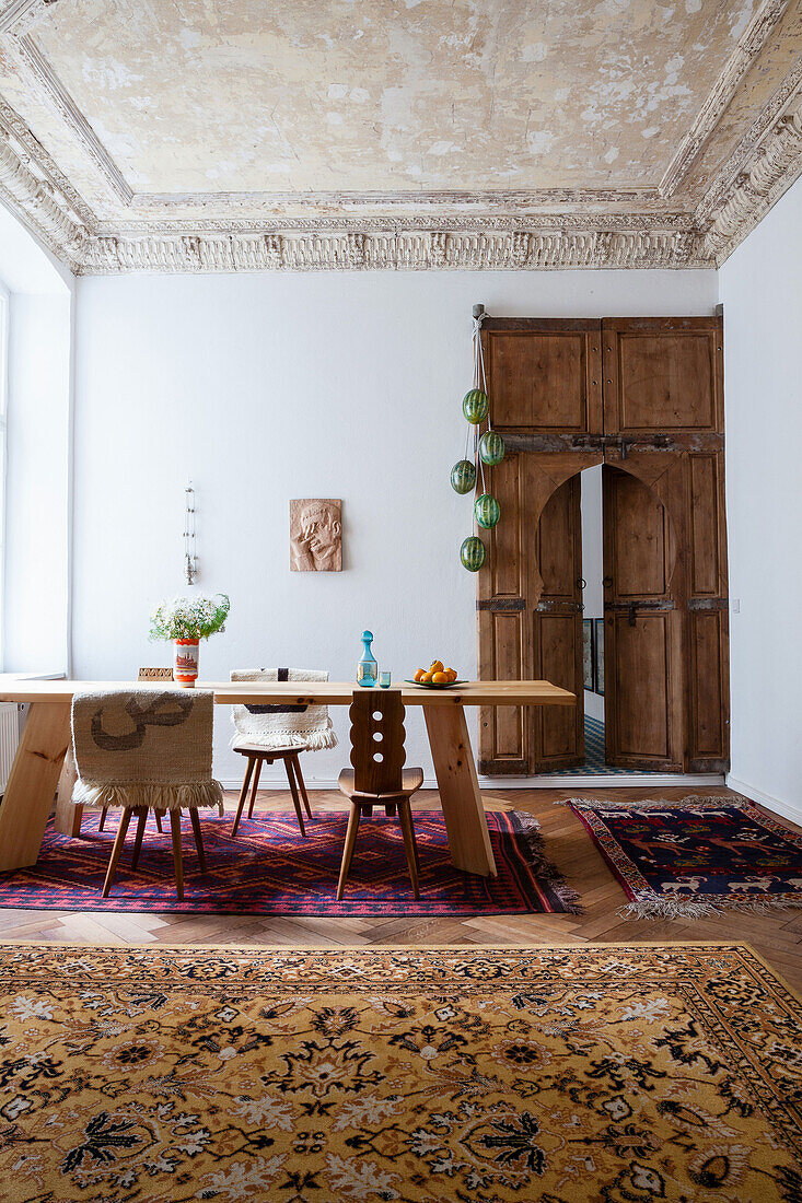 Wooden table with wooden chairs in the dining room with Moroccan door